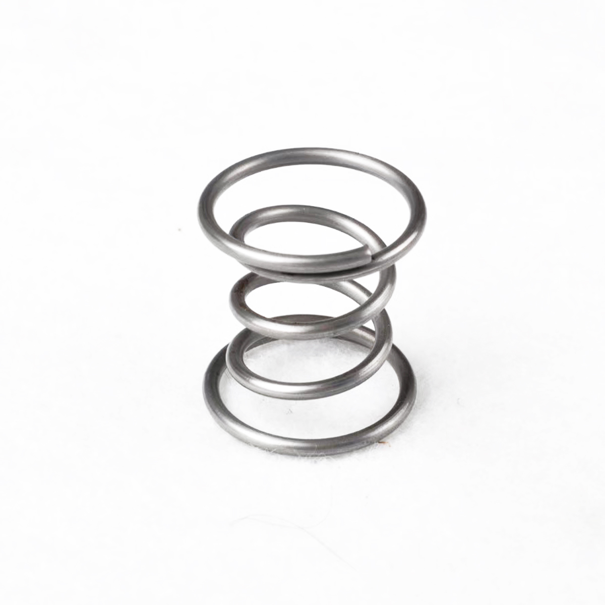 Small silver barrel spring with a narrow middle and wider ends