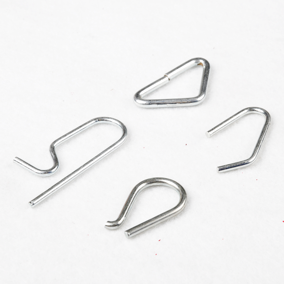 Assorted silver bent wire clips in triangle, hook and U shapes