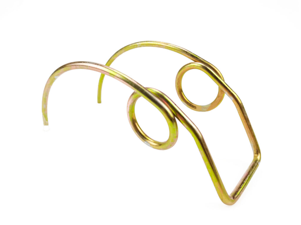 A yellow zinc-plated reel tine wire form made for a harvester header.