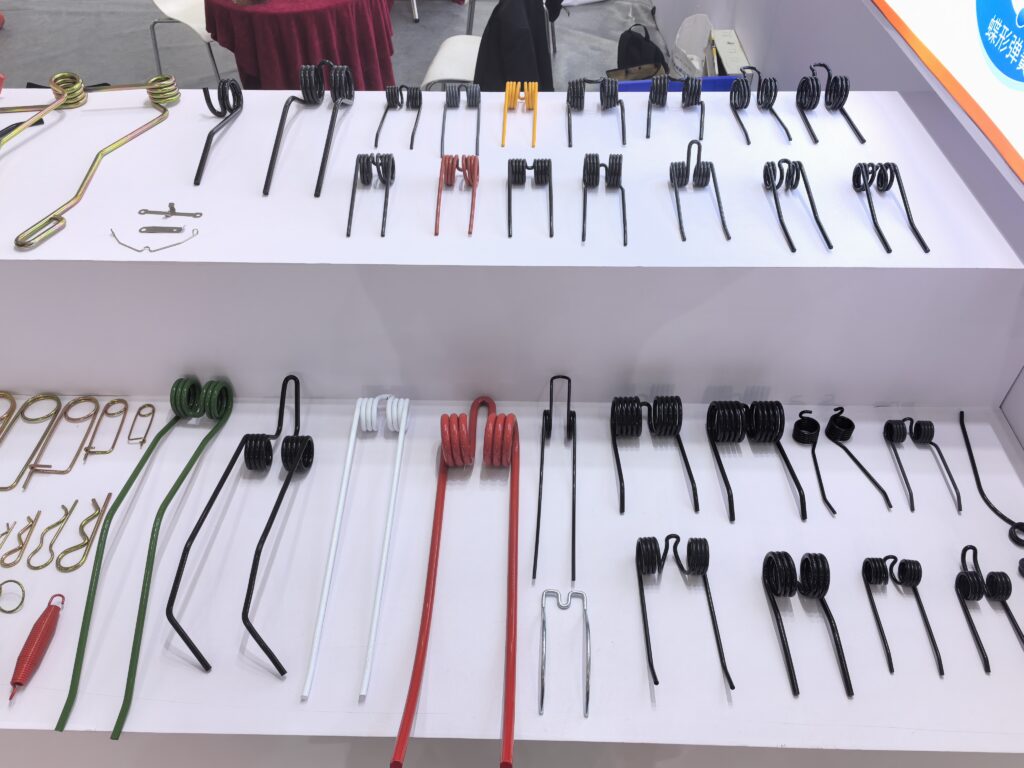 Spring tines and extension springs on display at the booth of group company Jiangsu Chaofan Spring Manufacturing at an agricultural machinery parts exhibition in China.