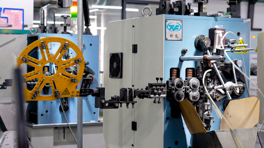 A YH-7140CNC coiling machine forming springs from wire.