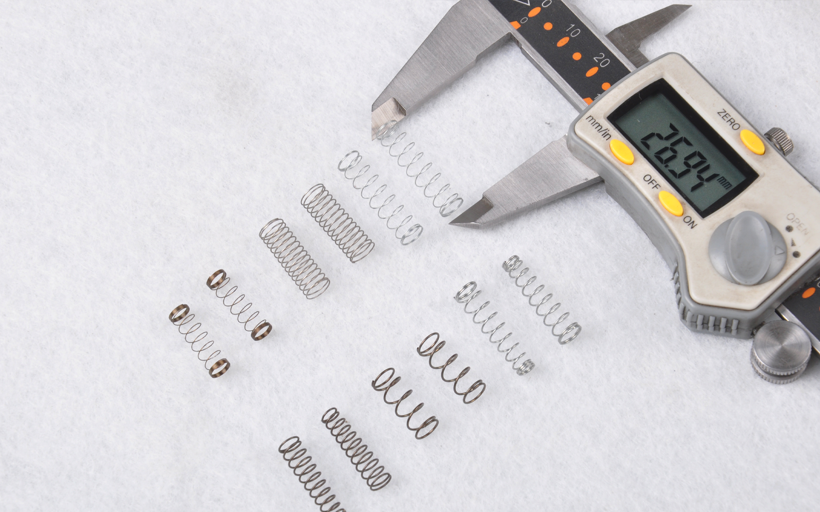 Spring engineer reviewing a CAD model and measuring a compression spring