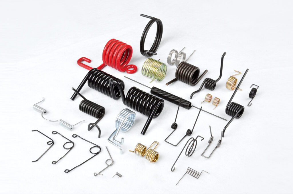 An assortment of torsion springs in black, red, yellow zinc, bright zinc and stainless, with straight, hooked and bent legs, including double torsion springs