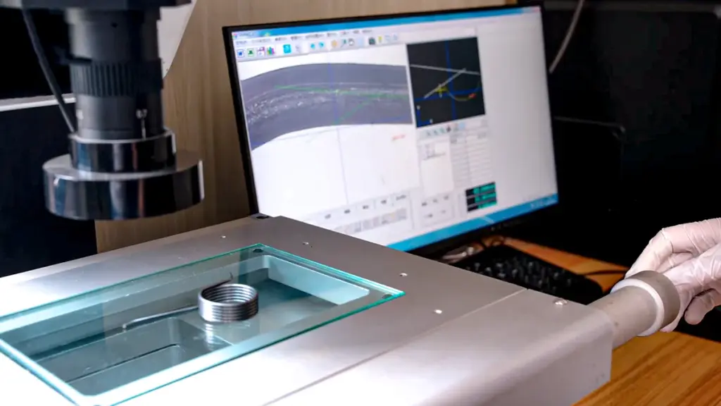 A vision measuring system with a spring part on the glass stage and the measured profile on the monitor
